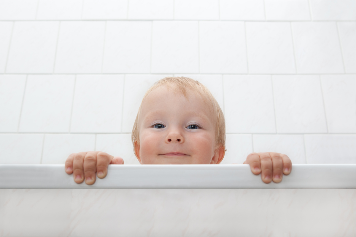 Ein Kind schaut über den Rand einer Badewanne